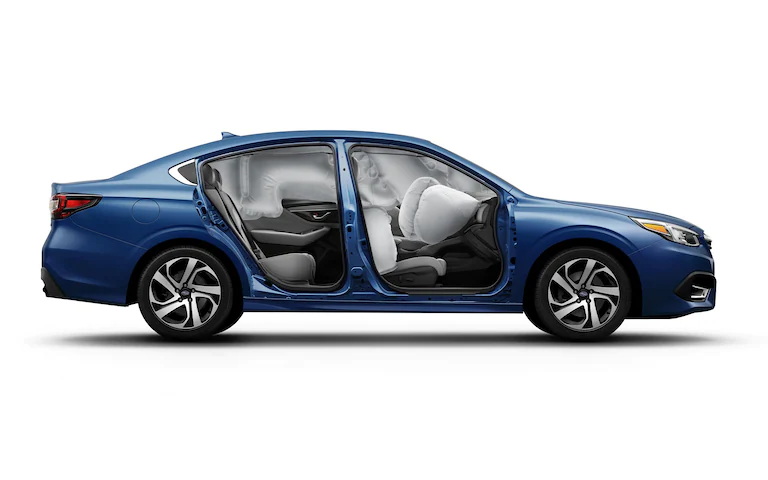 Side view of a blue 2022 Subaru Legacy with its doors open and airbags deployed