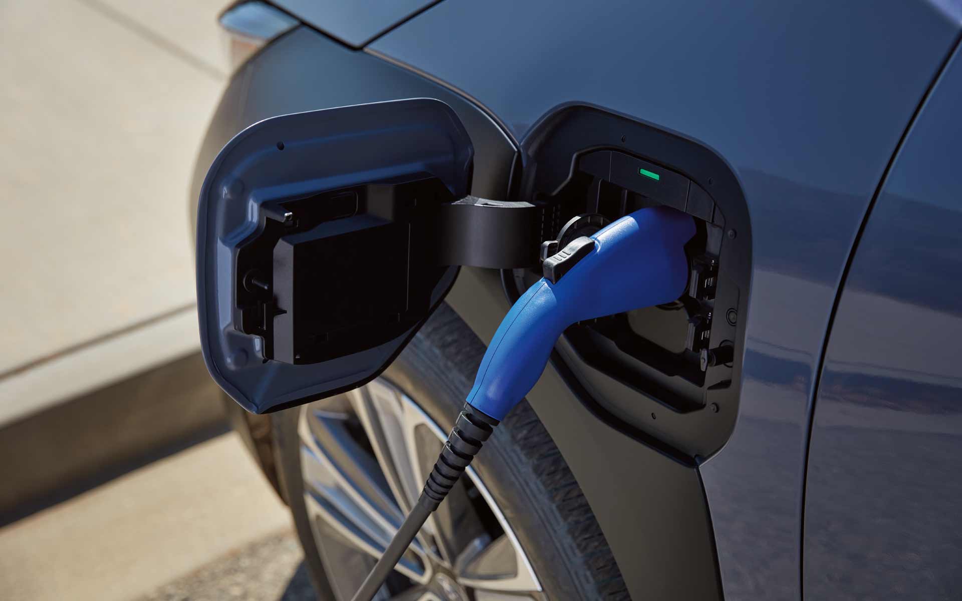 Close up of a vehicle charger plugged into a blue 2023 Subaru Solterra EV